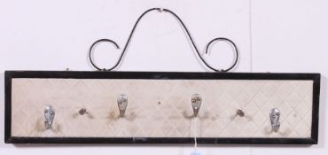 A 1950's vinyl stitched hanging coat rack stand having ebonised wooden surround.