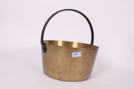 A 20th century brass jam pot with cast iron handle.