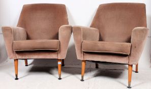 A good pair of 1960's retro velour upholstered armchairs of angular form being raised on turned,