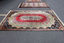A decorative hand woven Persian rug- on Red and Blue background with central panel.