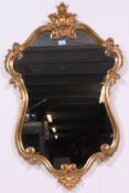 A good quality Antique style gilt rococo wall mirror of armorial shape having clean glass and back