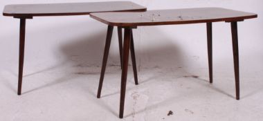A pair of mid century retro occasional tables being raised on tapered legs.