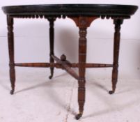 A Victorian mahogany and ebonised lozenge shaped centre table raised on turned legs with castors