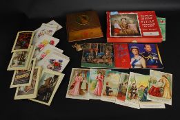 A collection of vintage unused postcards together with a Chad valley jigsaw puzzle, vintage tin,