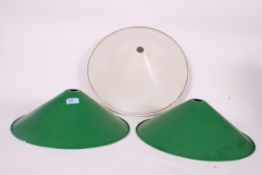 A collection of three vintage industrial pendant enamel light shades, two in green one in white.