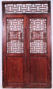 A fabulous pair of 20th cenutry Chinese hardwood doors having recessed lower panels with fret