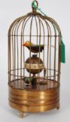 A Victorian style brass bird automaton clock, in the form of a caged song bird.