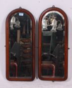 A pair of arched wall mirrors having mahogany frames. Measures: 69cm x 28cm.