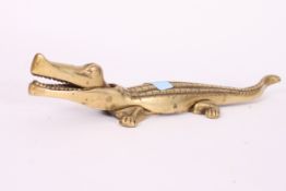 A 20th century brass novelty nut cracker in the form of an alligator.