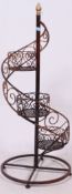 A contemporary garden / shop flower plant stand having swirled style with central pole and circular