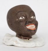 A ceramic early 20th century match holder / striker in the form of a negro pierrot.