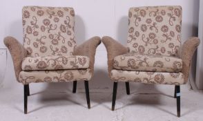 A vintage pair of 1950's / 1960's armchairs raised on ebonised tapered supports having fabulous two