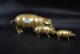 Three decrative graduating brass pigs