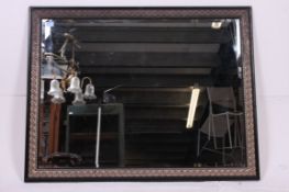 A large early to mid 20th  century ebonised rectangular wall mirror with bevelled edge mirror set
