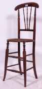 A 19th century continental beech wood haberdashery shop counter seat chair with cane seat.