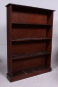 A large open window early 20th century bookcase cabinet having plinth base with fixed shelves and