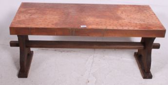 A vintage 20th century wooden and copper top rectangular coffee table raised on shaped supports.