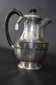 A silver hallmarked coffee pot of large proportions by Kemp Brothers having ebonised swirl handle