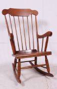 A 20th century antique style Windsor rocking chair raised on sleigh runners with panel seat and