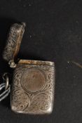 A Victorian silver hallmarked vesta case being rococo chase decorated with plain cartouche,
