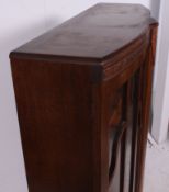 A 1930's Art Deco oak display cabinet having shaped feet with twin doors and a shelved interior.