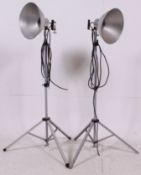 A pair of photax retro studio  lamps having polished metal shades complete on the original tripods.
