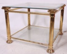 An antique style brass and glass square coffee table raised on angled corner supports with finial