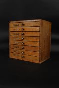 An early 20th century Industrial wooden printers desk top cabinet chest of drawers.