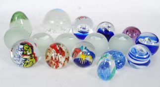 A large quantity (17) of glass paperweights to include control bubble and others.