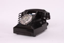 A vintage mid century bakelite telephone with cheese tray having a later modern conversion
