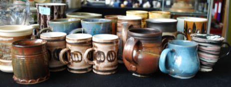 Approx twenty Somerset pottery mugs in varying designs.