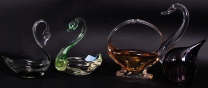 A collection of 4x pieces of studio art glass to include three glass swans and another piece.