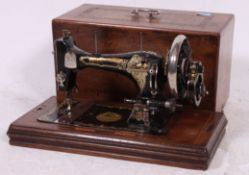 A Victorian mahogany inlaid cased sewing machine - The Faringdon Favourite.