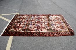 A good quality Persian rug stylised with geometric patterns having central beige ground with