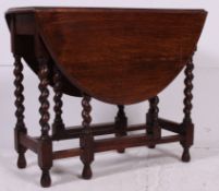 A 1930's oak drop leaf barley twist occasional / side dining table having oval drop leaves above .