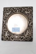 A stunning silver photograph frame with embossed and pierced decoration with cherubs around a