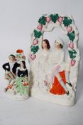 An early 20th century Staffordshire flatback figurine / diorama of a courting couple together with