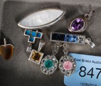 A collection of silver necklace pendants to include ingot, mother of pearl turquoise stone cross,