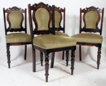 A set of 4 Edwardian mahogany dining chairs having spindle gallery top rails with overstuffed seat