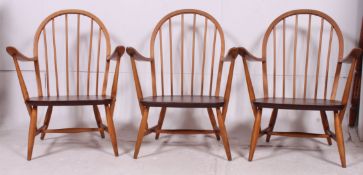 A set of 3 1970's Ercol windsor pattern armchairs having stub legs united by stretchers with
