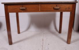 A mid 20th century Air Ministry style solid oak school desk raised on squared legs with twin frieze