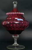 An early 20th century large ruby / cranberry glass bon bon dish with lid raised over clear glass