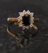 A 9ct hallmarked gold ladies black diamond ring having 12 1.5pt diamond chip stones to surround.