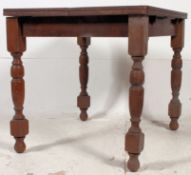A 1940's draw leaf beech wood dining table raised on block and turned legs having fold over leaves