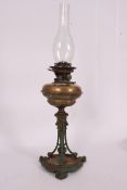 A large 19th century brass cast oil lamp of rococo form having central reservoir with flue atop