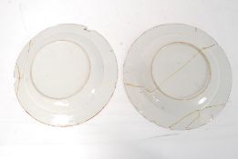 A pair of 18th century blue and white delft / Chinese plates having foliate decoration with