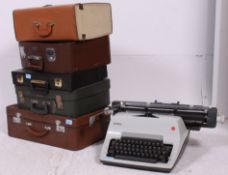 A stack of vintage suitcases to include 1950's examples along with a vintage typewriter and a