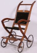 A 19th century walnut and velour upholstered push chair / pram with original metal wheels.