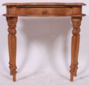 An antique style pine console / side hall table having serpentine shaped top with single frieze