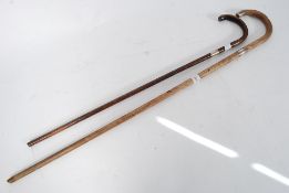 A silver collared walking stick both with faux bamboo tapering stems having crook tops being